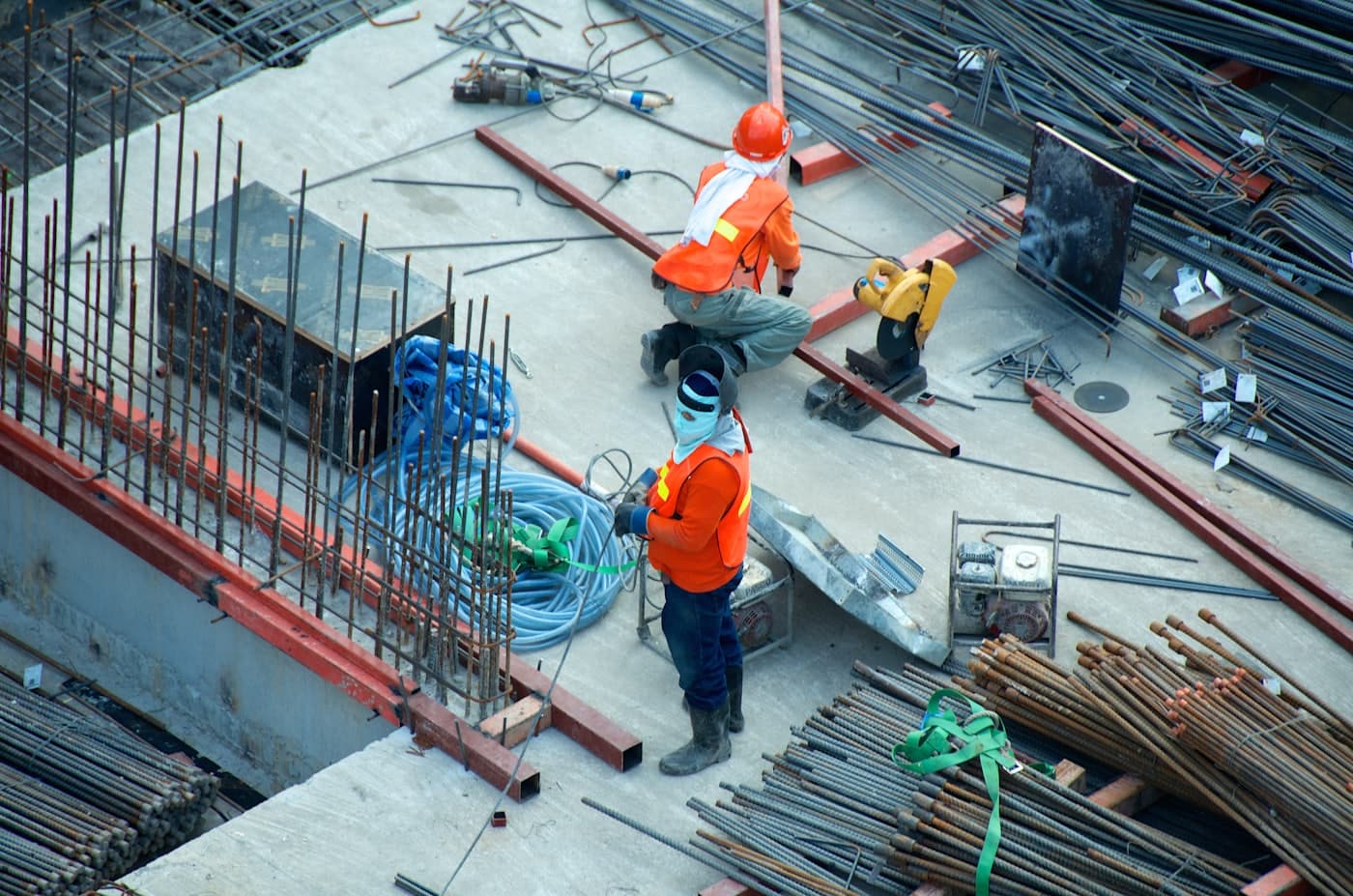 Construction workers in hard hats and high-visibility vests on an active build site